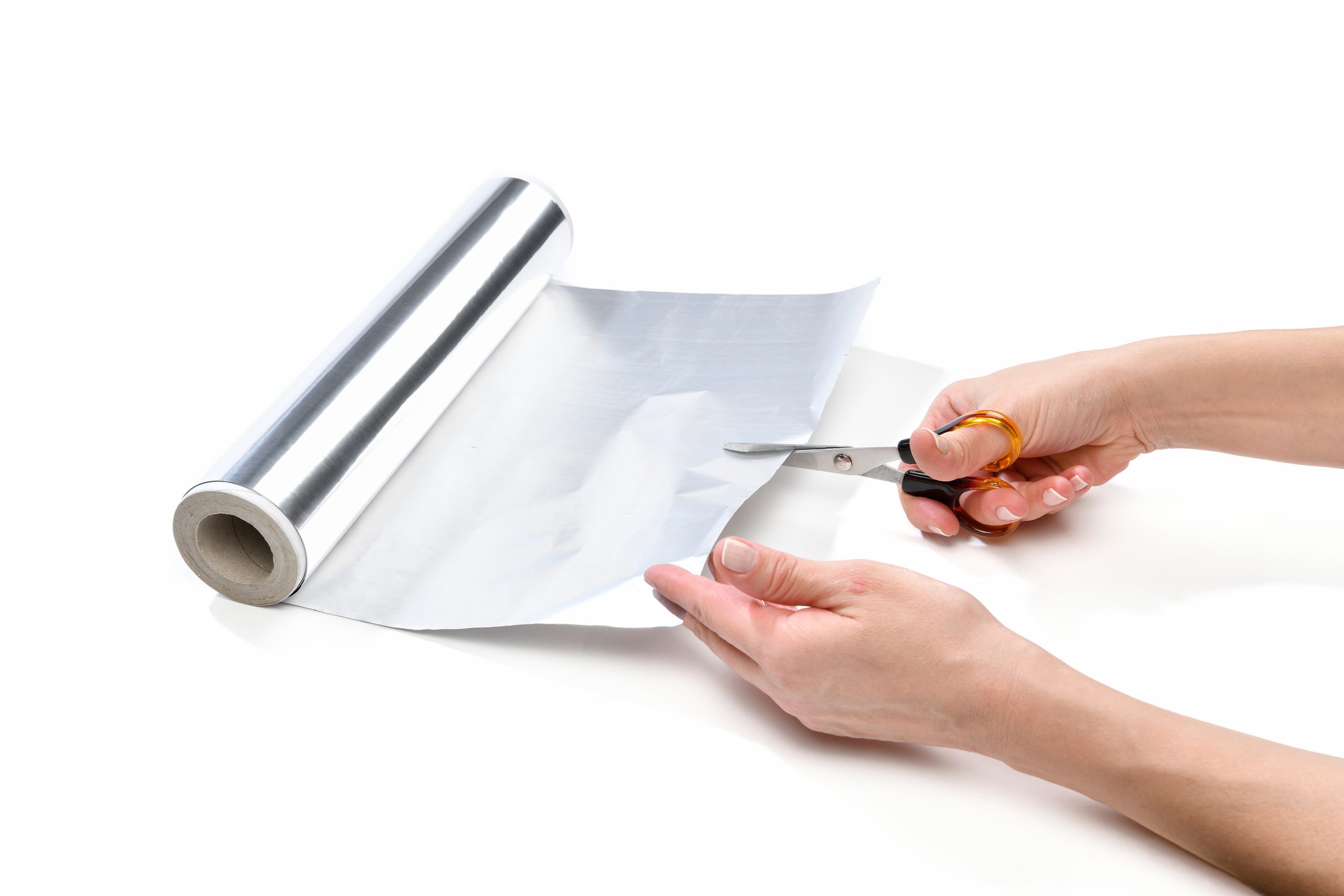 Lifehack, female hand cutting aluminum foil to sharpen scissors